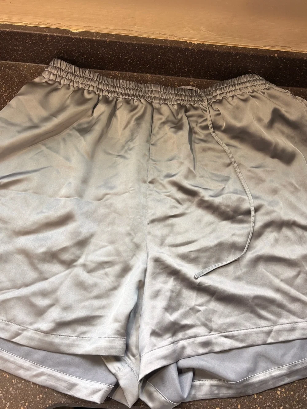SKIMS Sporty Satin Loose Short in the metallic silver shade called Mirror